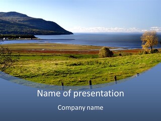A Green Field With A Lake In The Background PowerPoint Template