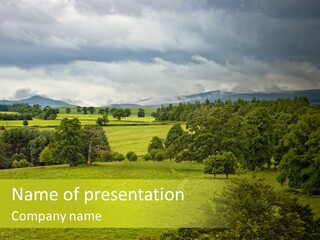 A Green Field With Trees And Mountains In The Background PowerPoint Template