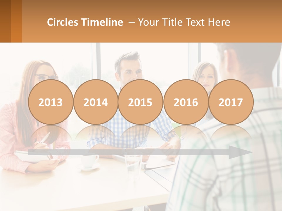 A Group Of People Sitting Around A Table PowerPoint Template
