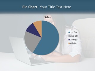 A Woman Sitting At A Desk Using A Laptop Computer PowerPoint Template