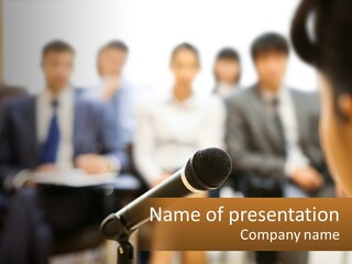 A Microphone In Front Of A Group Of People PowerPoint Template