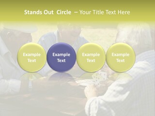 A Group Of Elderly Men Playing Cards At A Picnic Table PowerPoint Template