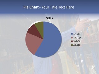 A Man In A Warehouse Is Looking At A Piece Of Paper PowerPoint Template