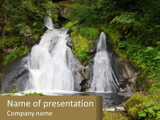 A Waterfall In The Middle Of A Lush Green Forest PowerPoint Template