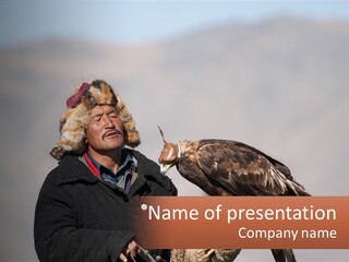 A Man Holding A Bird Of Prey In His Hand PowerPoint Template