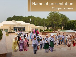 A Group Of People Walking Down A Street Next To A Building PowerPoint Template