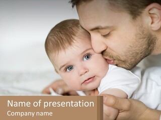 A Man Holding A Baby In His Arms PowerPoint Template