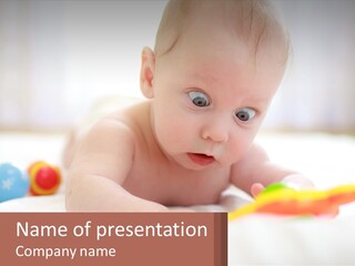 A Baby Laying On A Bed With A Toy PowerPoint Template