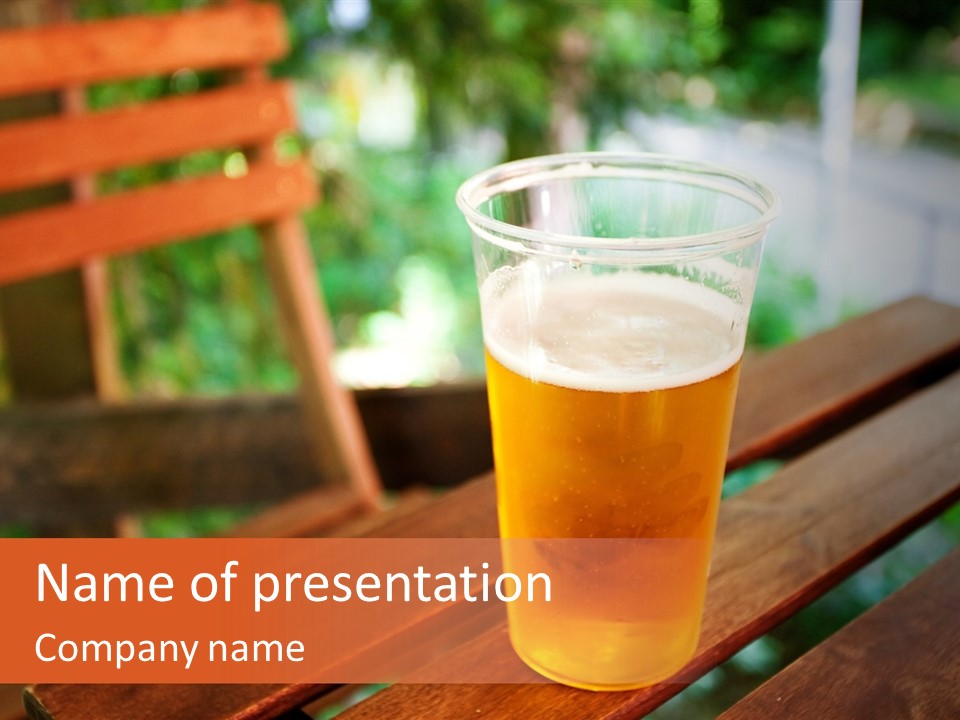 A Glass Of Beer Sitting On Top Of A Wooden Table PowerPoint Template