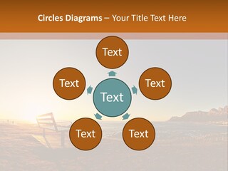 A Bench Sitting On Top Of A Sandy Beach PowerPoint Template