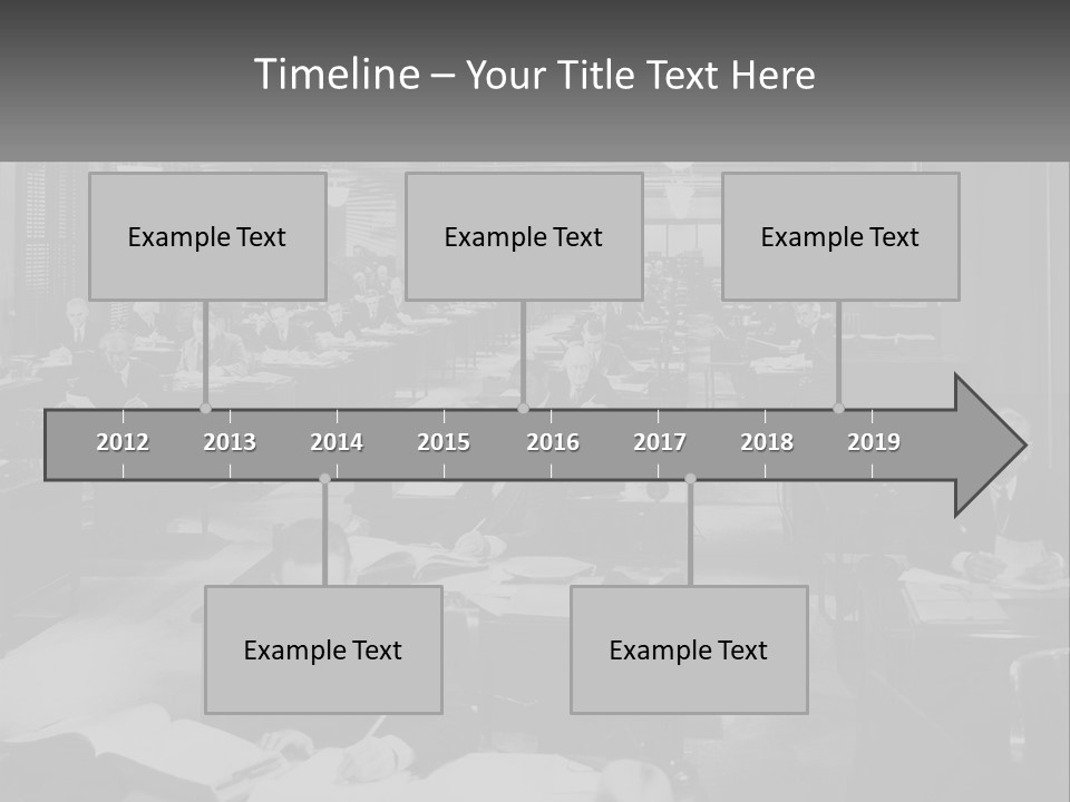 A Group Of People Sitting At Desks In A Room PowerPoint Template
