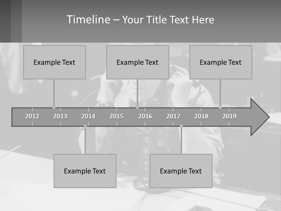 A Man Sitting At A Desk Talking On A Phone PowerPoint Template