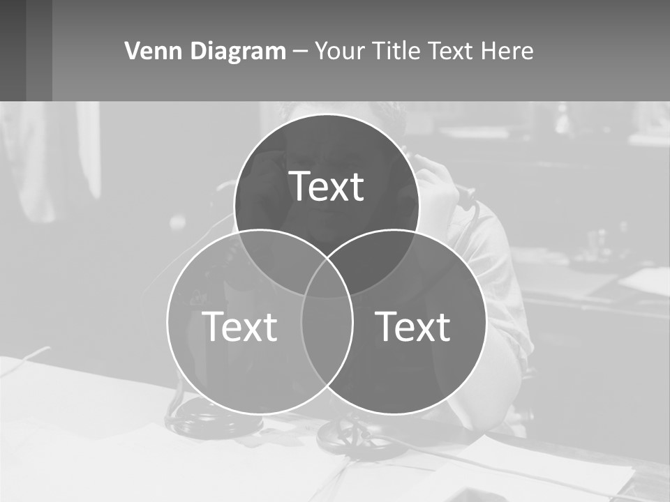 A Man Sitting At A Desk Talking On A Phone PowerPoint Template