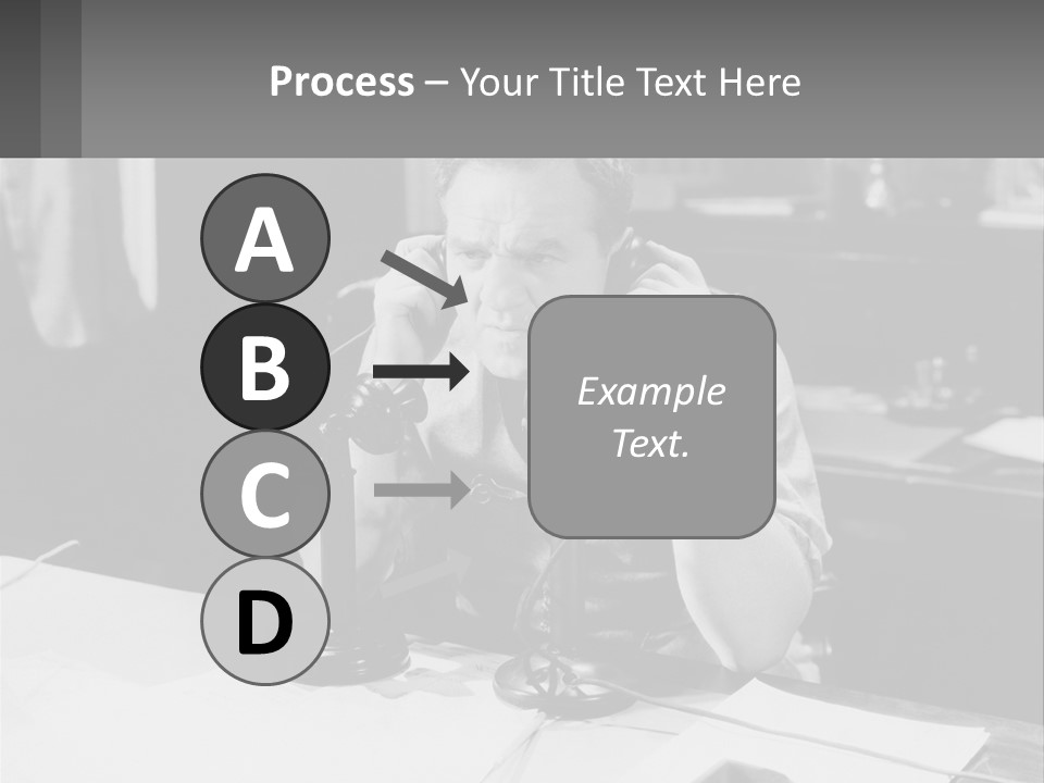 A Man Sitting At A Desk Talking On A Phone PowerPoint Template