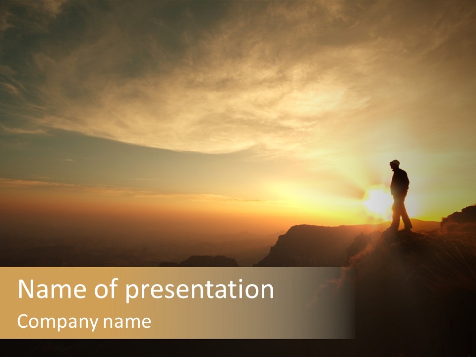 A Man Standing On Top Of A Mountain At Sunset PowerPoint Template