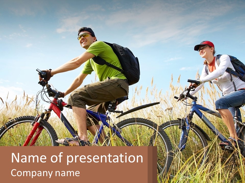 A Couple Of People Riding Bikes Through A Field PowerPoint Template