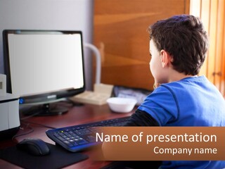 A Young Boy Sitting At A Desk With A Computer PowerPoint Template