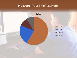 A Young Boy Sitting At A Desk With A Computer PowerPoint Template