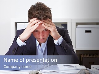 A Man Sitting At A Desk With His Hands On His Head PowerPoint Template