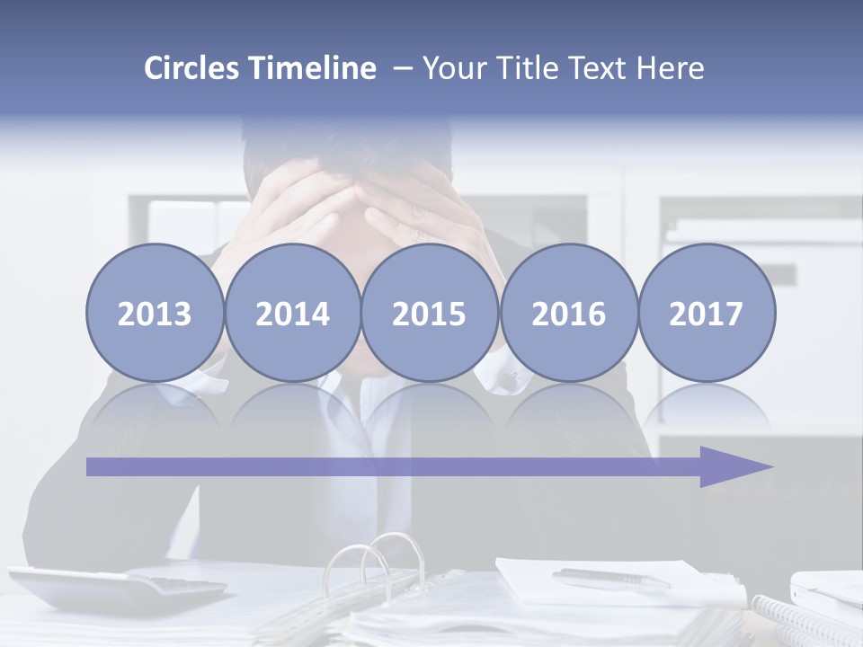 A Man Sitting At A Desk With His Hands On His Head PowerPoint Template