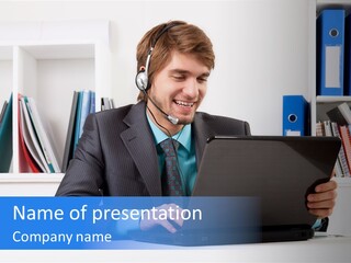 A Man Wearing A Headset And Using A Laptop PowerPoint Template