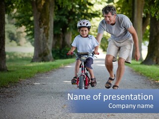 A Man Teaching A Boy How To Ride A Bike PowerPoint Template