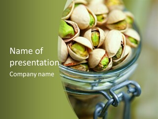 A Glass Jar Filled With Pistachios On Top Of A Table PowerPoint Template