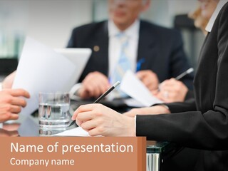 A Group Of People Sitting At A Table Writing On Paper PowerPoint Template