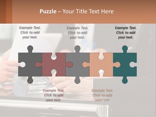 A Group Of People Sitting At A Table Writing On Paper PowerPoint Template