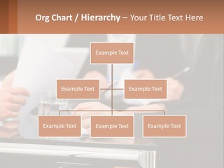 A Group Of People Sitting At A Table Writing On Paper PowerPoint Template