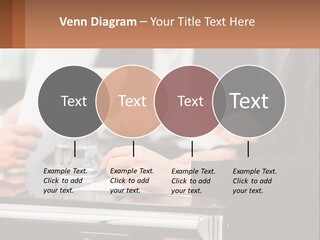 A Group Of People Sitting At A Table Writing On Paper PowerPoint Template