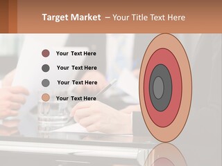 A Group Of People Sitting At A Table Writing On Paper PowerPoint Template