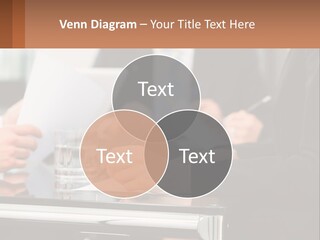 A Group Of People Sitting At A Table Writing On Paper PowerPoint Template