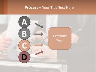 A Group Of People Sitting At A Table Writing On Paper PowerPoint Template