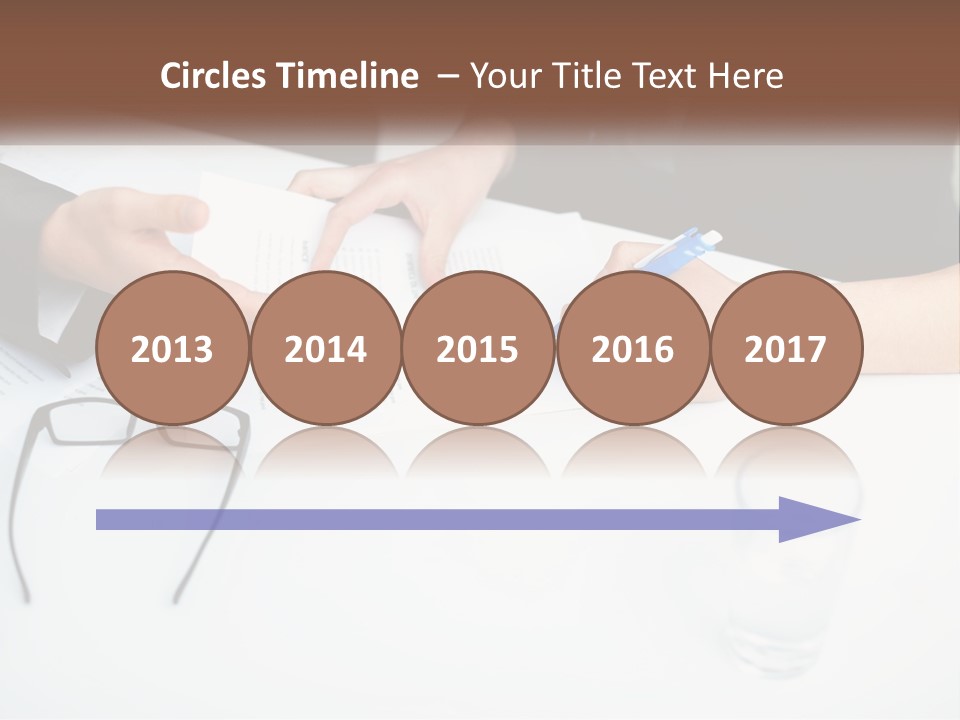 Two People Sitting At A Table Signing Papers PowerPoint Template