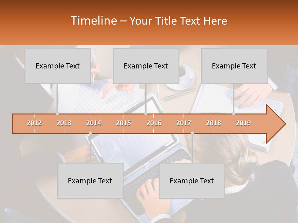 A Group Of People Sitting At A Table Working On Laptops PowerPoint Template