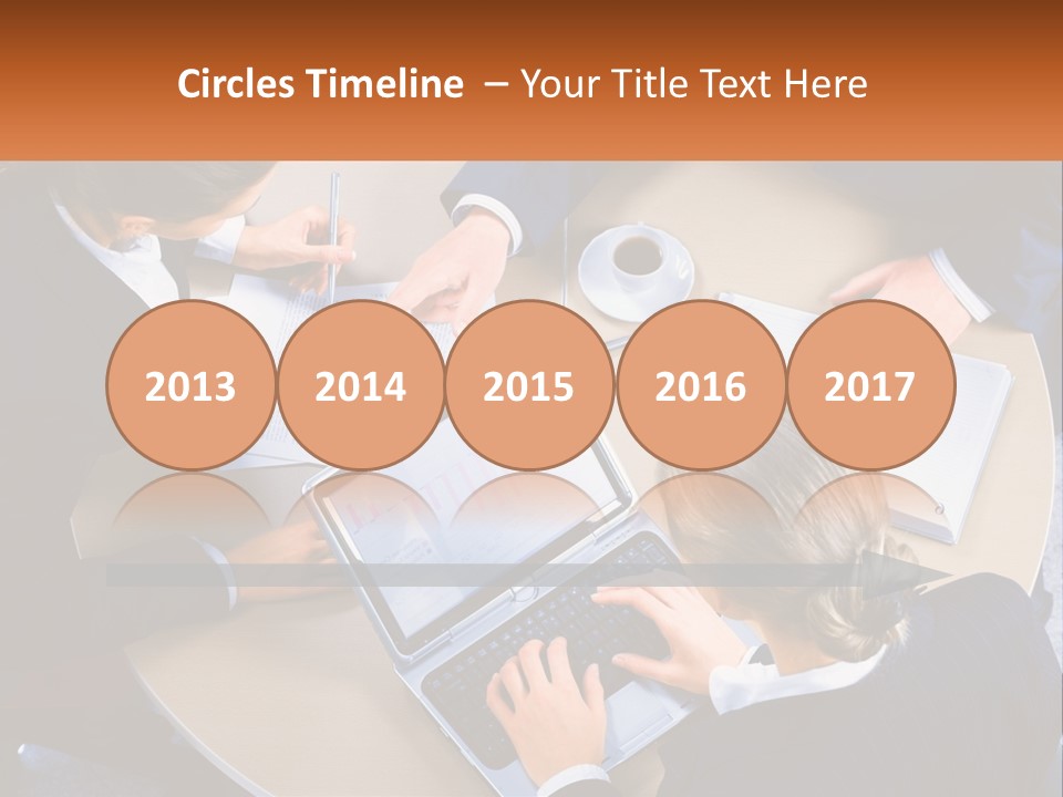 A Group Of People Sitting At A Table Working On Laptops PowerPoint Template