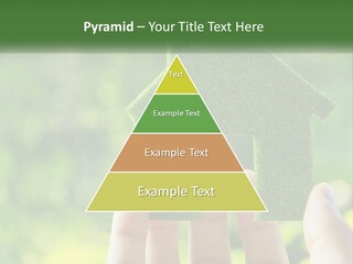 A Person Holding A Small Green House In Their Hands PowerPoint Template