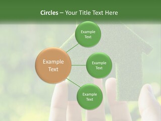 A Person Holding A Small Green House In Their Hands PowerPoint Template