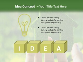 A Person Holding A Small Green House In Their Hands PowerPoint Template