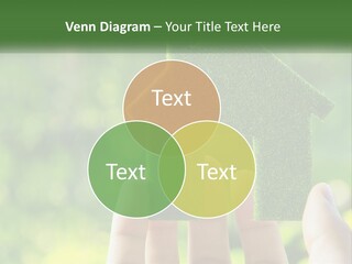 A Person Holding A Small Green House In Their Hands PowerPoint Template