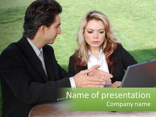 A Man And Woman Sitting At A Table Looking At A Laptop PowerPoint Template