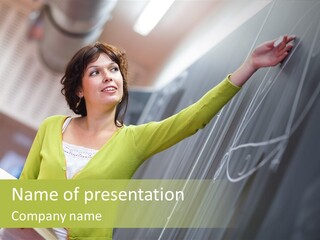 A Woman Writing On A Blackboard In A Classroom PowerPoint Template