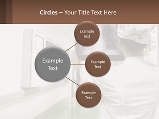 A Woman In A White Lab Coat Is Looking At A X - Ray PowerPoint Template