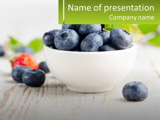 A White Bowl Filled With Blueberries On Top Of A Wooden Table PowerPoint Template