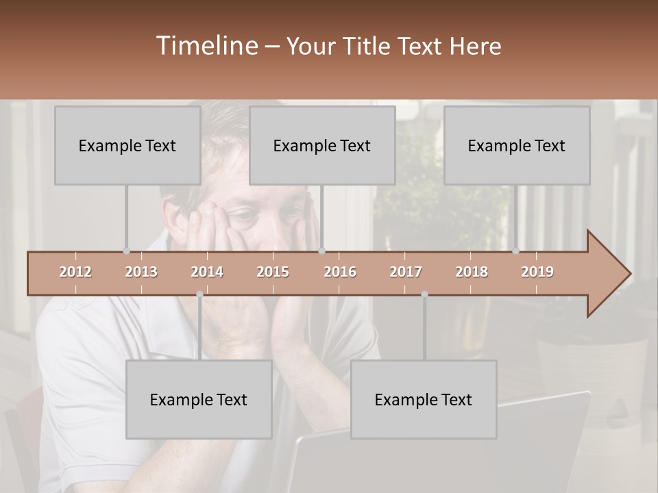 A Man Sitting At A Table With A Laptop In Front Of Him PowerPoint Template