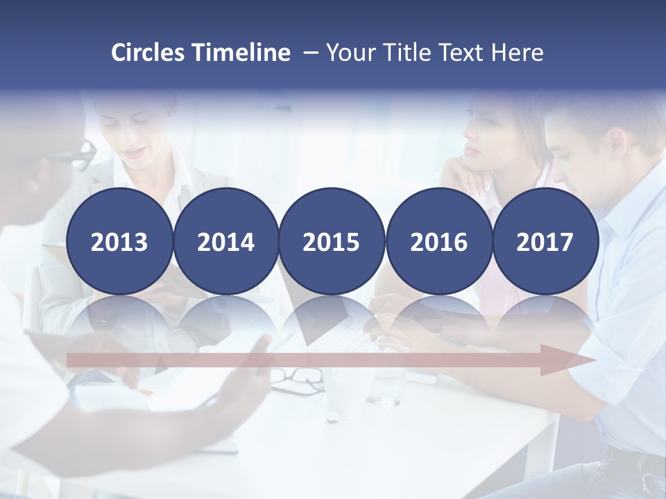 A Group Of People Sitting Around A Table With A Laptop PowerPoint Template