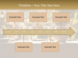 A Table Topped With Two Wine Glasses And A Vase Filled With Flowers PowerPoint Template