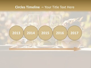 A Table Topped With Two Wine Glasses And A Vase Filled With Flowers PowerPoint Template