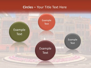 A Fountain In Front Of A Row Of Multi - Colored Buildings PowerPoint Template